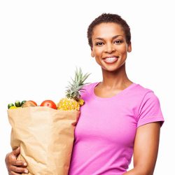 Portrait of a happy African American woman holding bag of healthy groceries. Horizontal shot. Isolated on white.